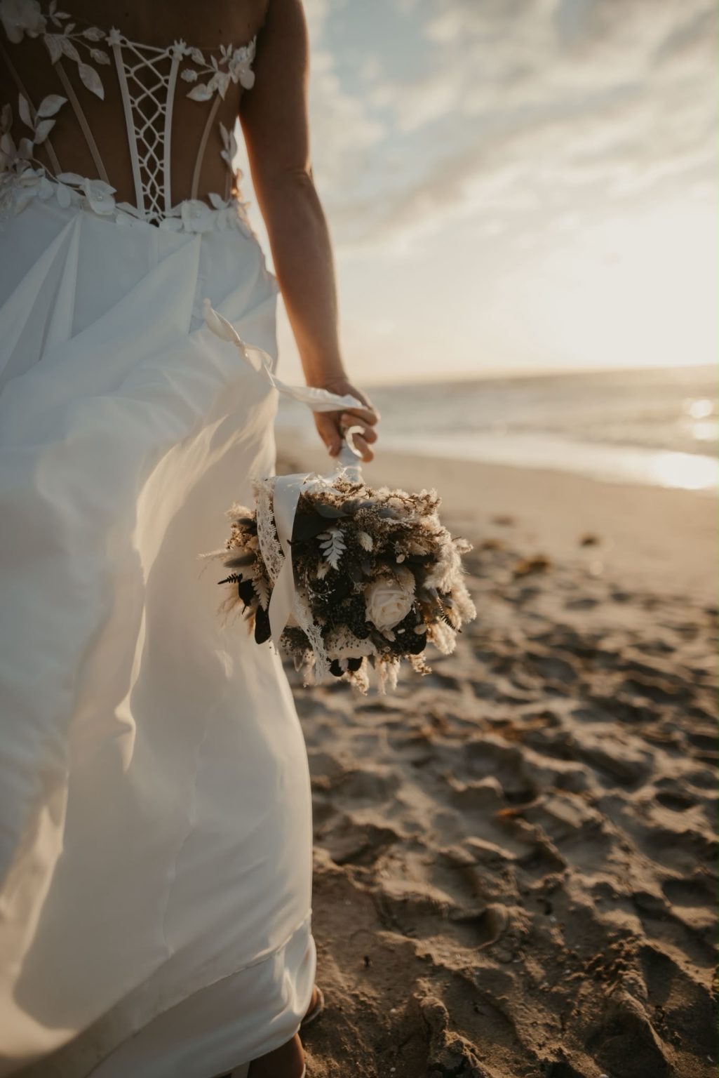 Braut mit Brautstrauß am Strand von Ahrenshoop
