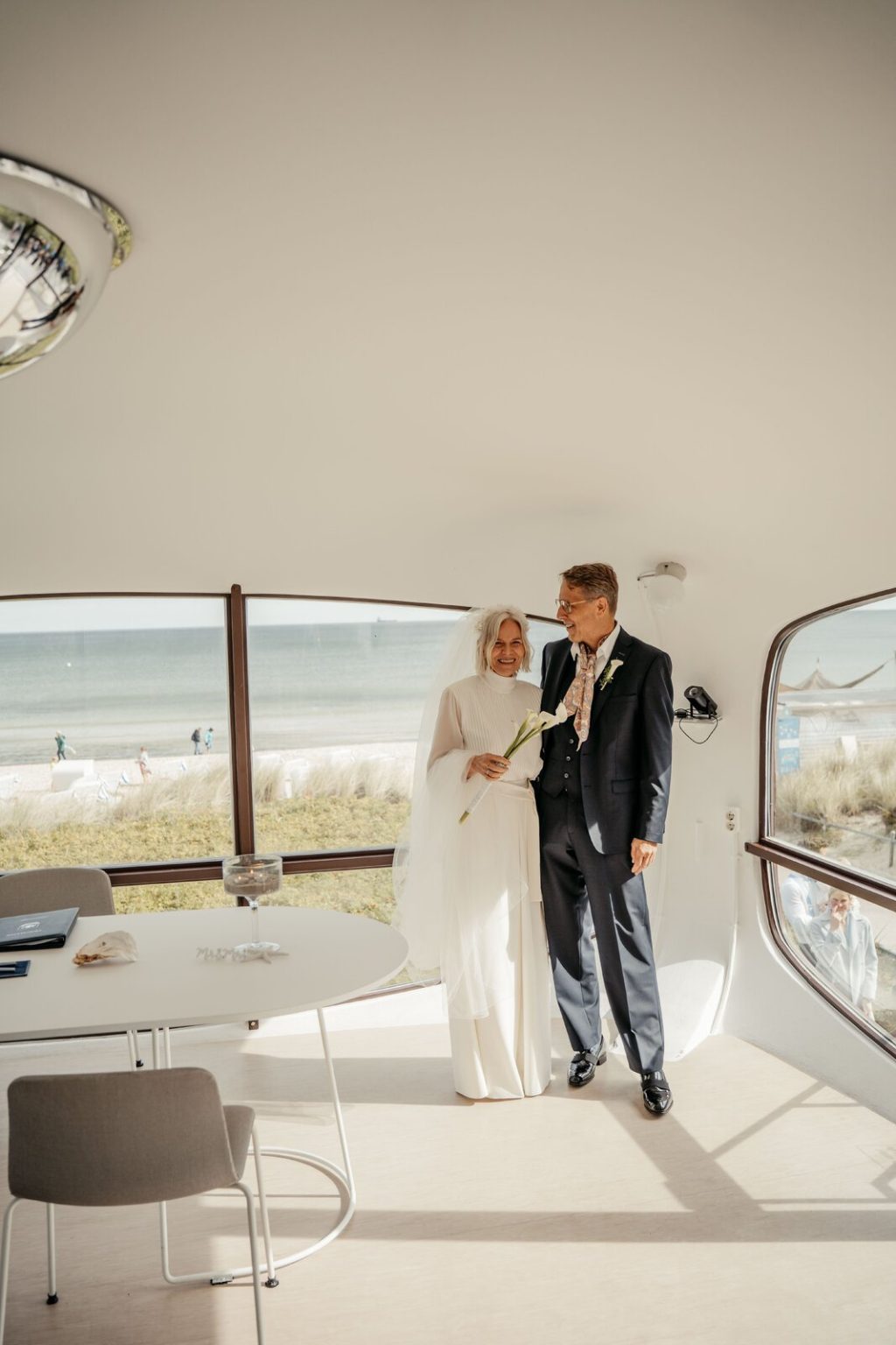 Brautpaar im Müther-Turm in Binz vor den Fenstern mit Blick auf die Ostsee