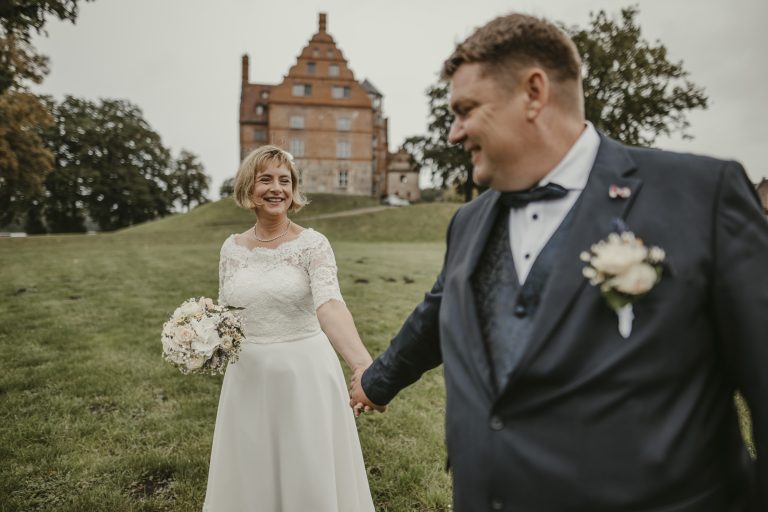 Brautpaar Hand in Hand vor Schloss Ulrichshusen
